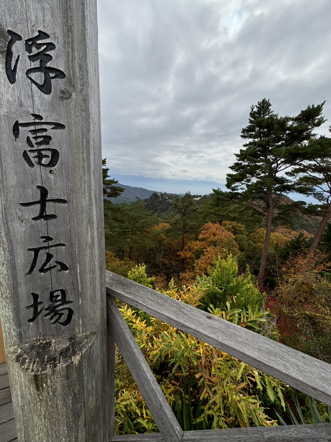 「浮富士広場」と書かれた木の柱と、紅葉した山