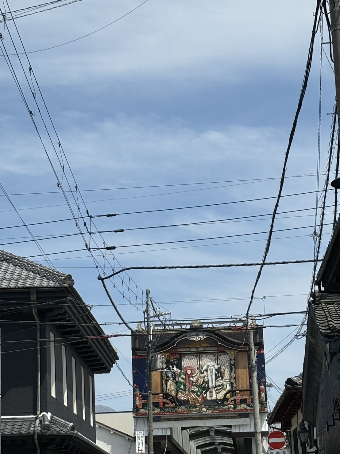町の通りの上に見える、歌舞伎の人形がかざられた曳山